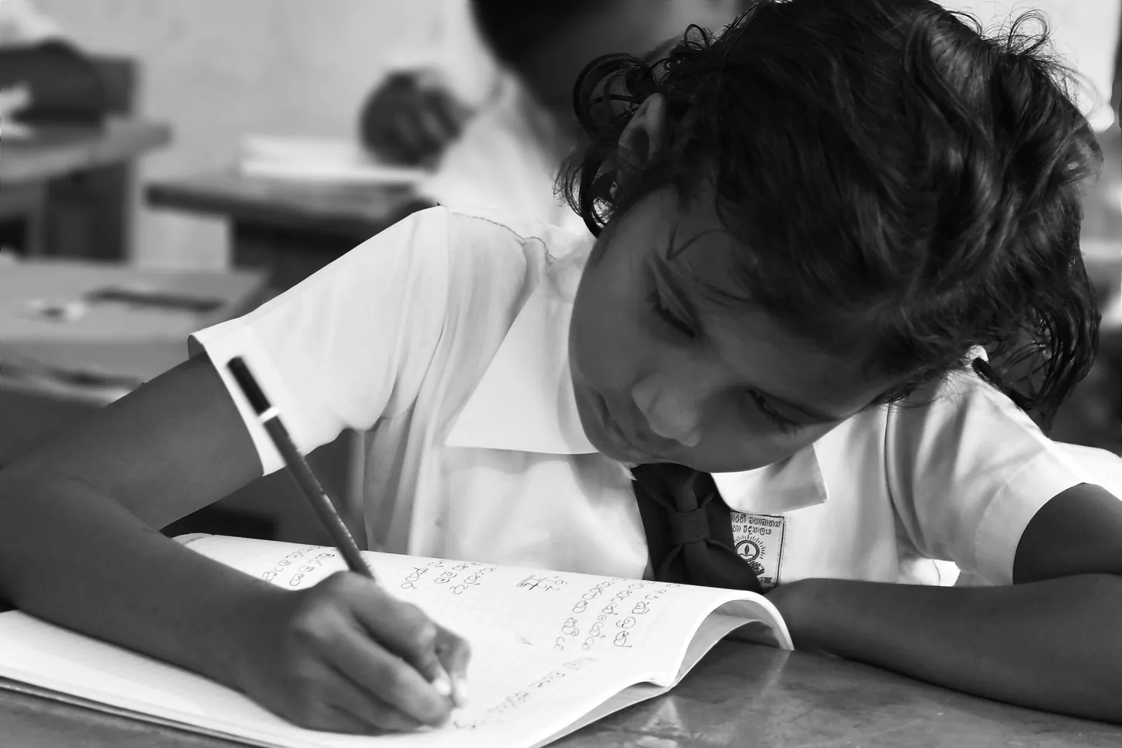 Student writing in a notebook in a classroom